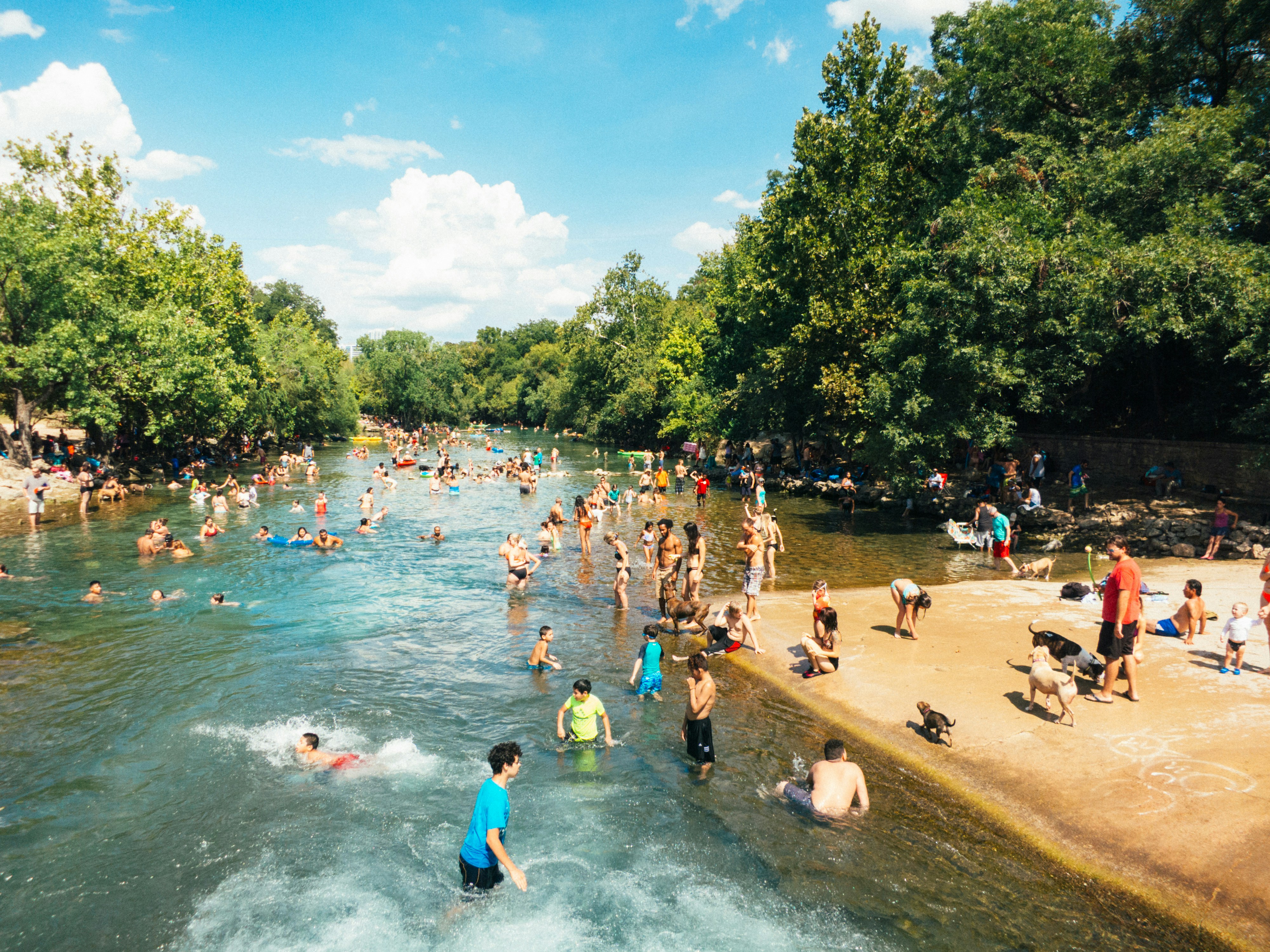 Right behind end fance of Barton Springs pool many locals enjoy refreshing waters of the springs with their dogs. The place is free-for-all. Here you can meet all kinds of people; this photo was taken from Barton Springs pool side in one of the hot Sundays in August.